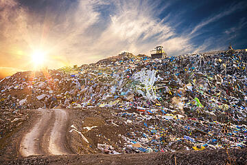 Pollution concept. Garbage pile in trash dump or landfill at sunset.