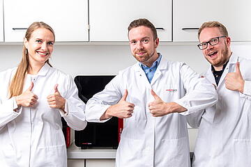 Three persons team Life Science Solutions thumbs up